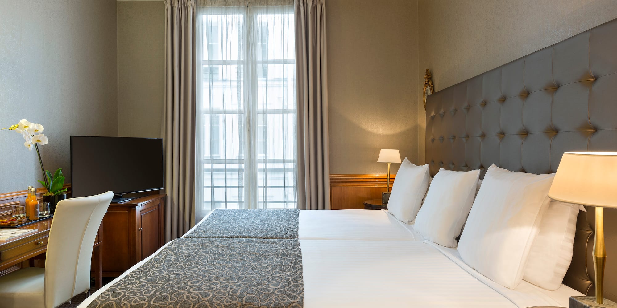 a bed with a tv and a chair in a room