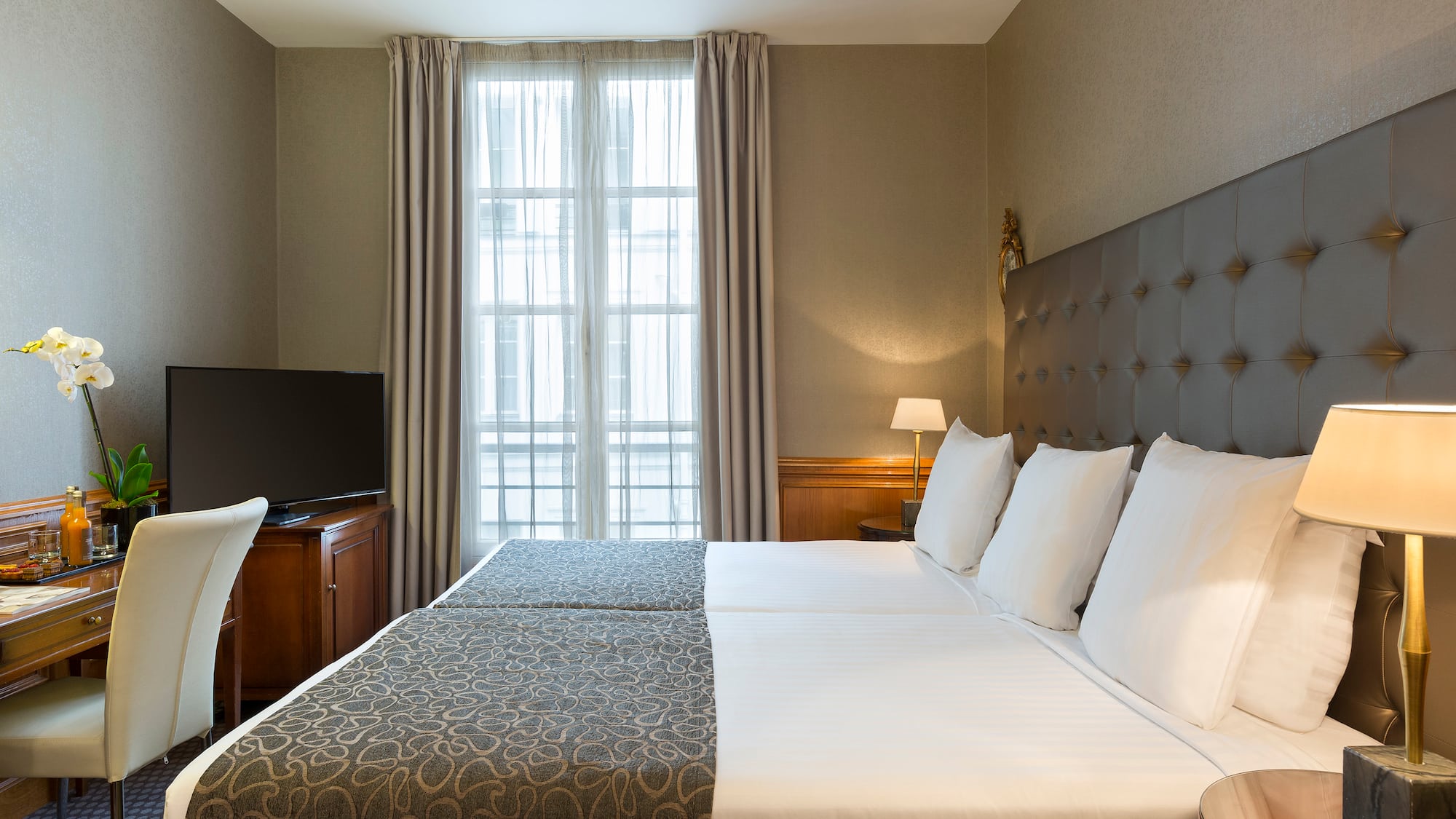 a bed with a tv and a chair in a room