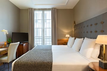 a bed with a tv and a chair in a room