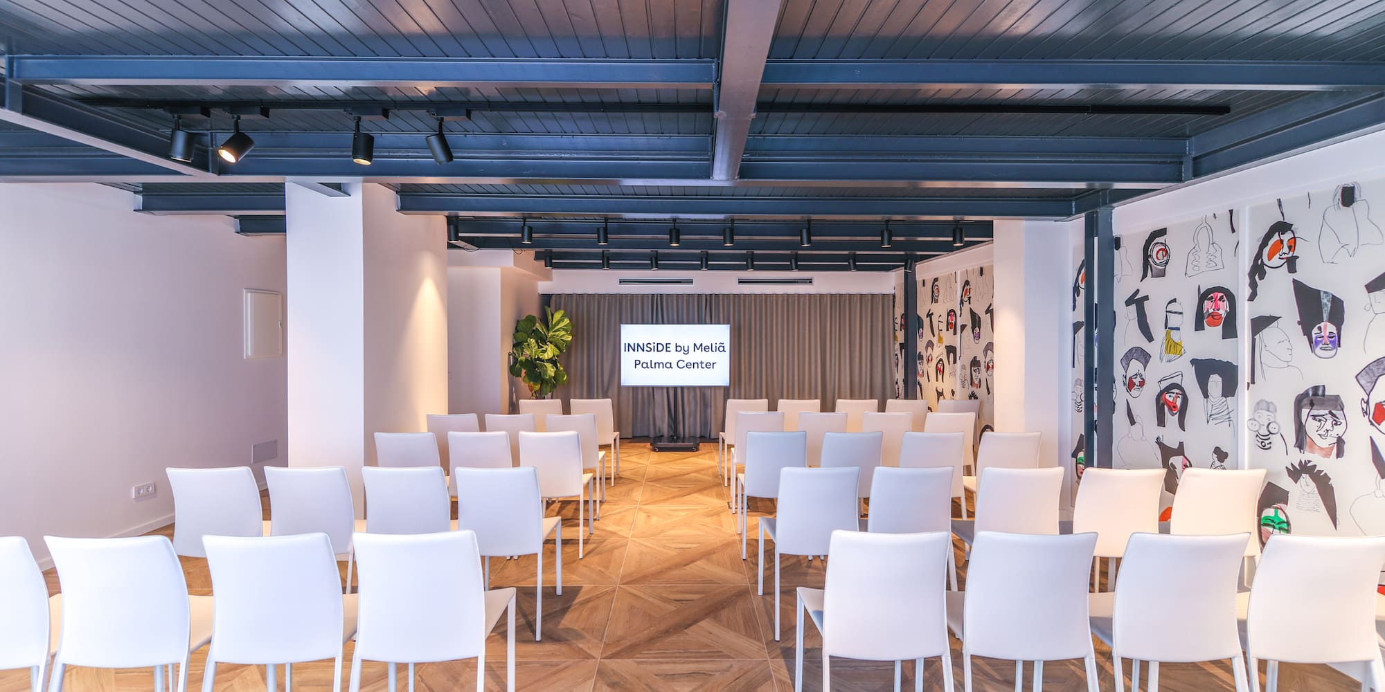 a room with white chairs and a wood floor