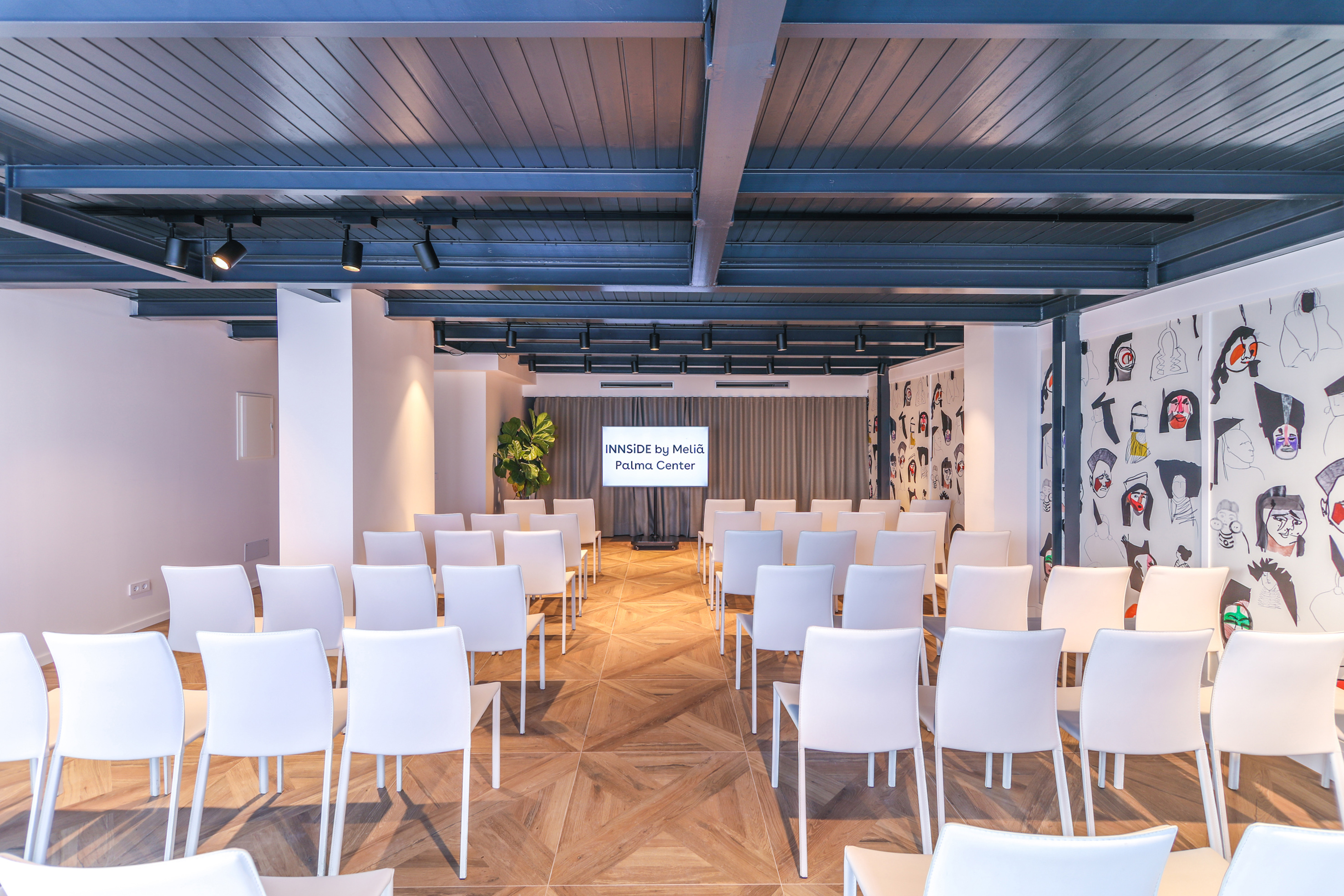 a room with white chairs and a wood floor