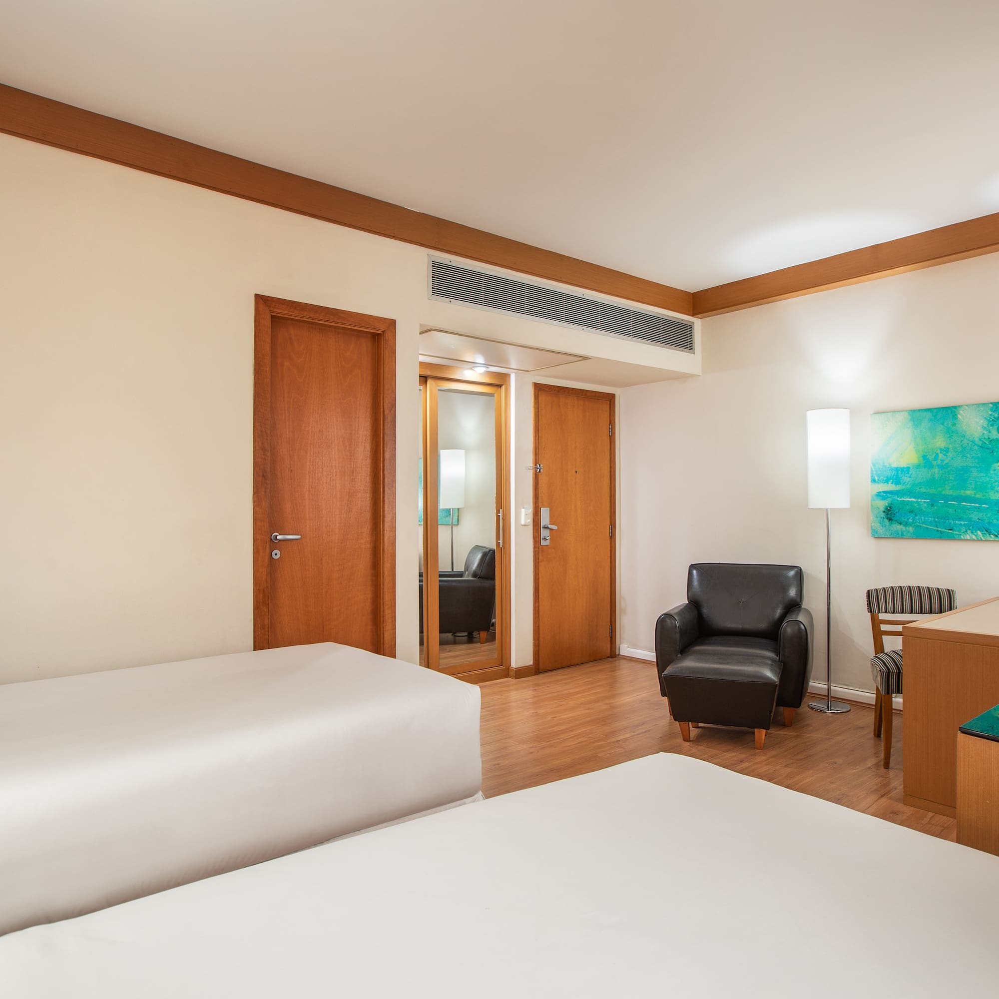 a room with two beds and a chair