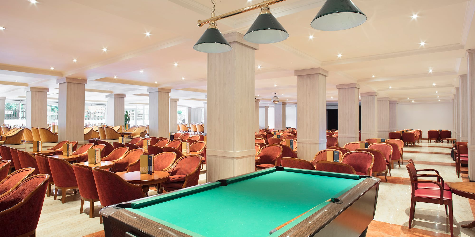 a pool table in a room with chairs and tables