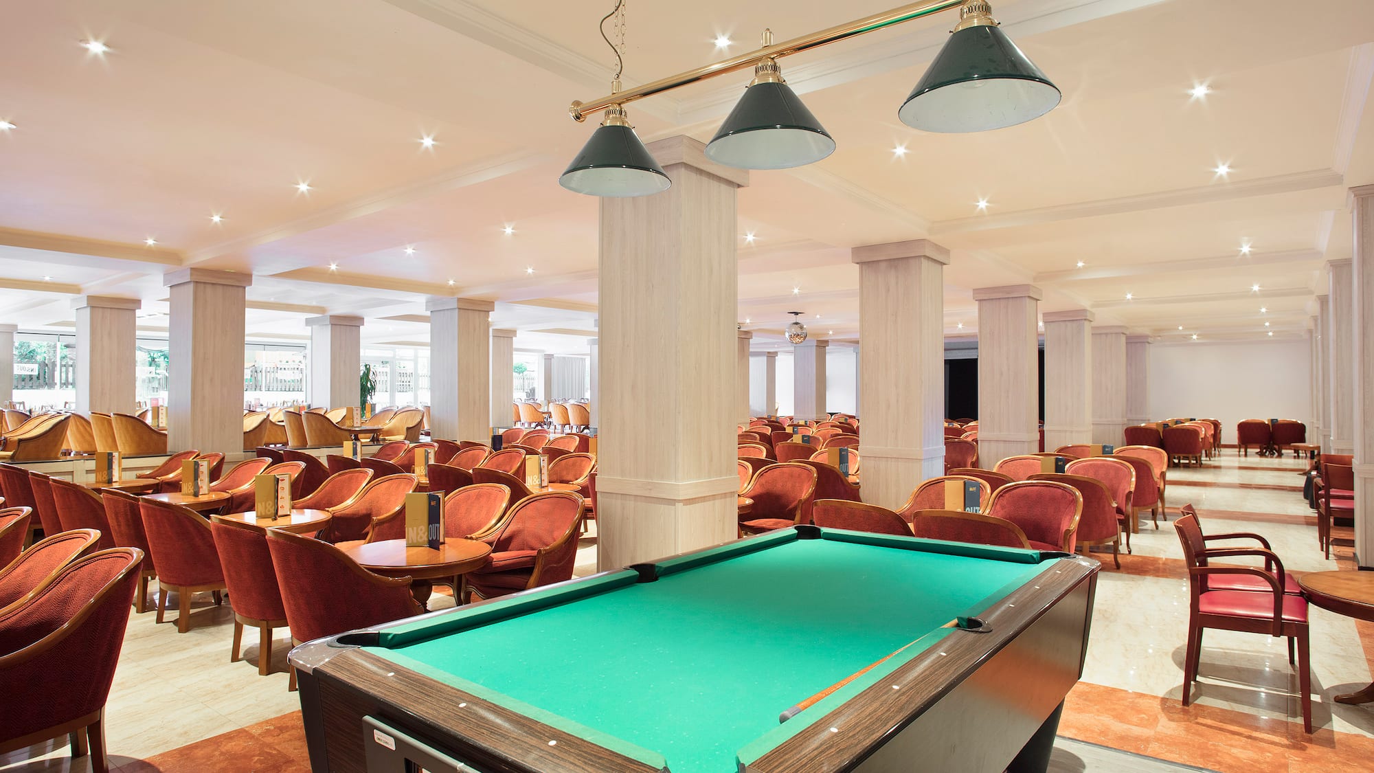 a pool table in a room with chairs and tables