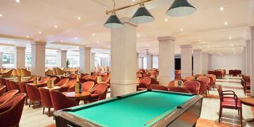 a pool table in a room with chairs and tables