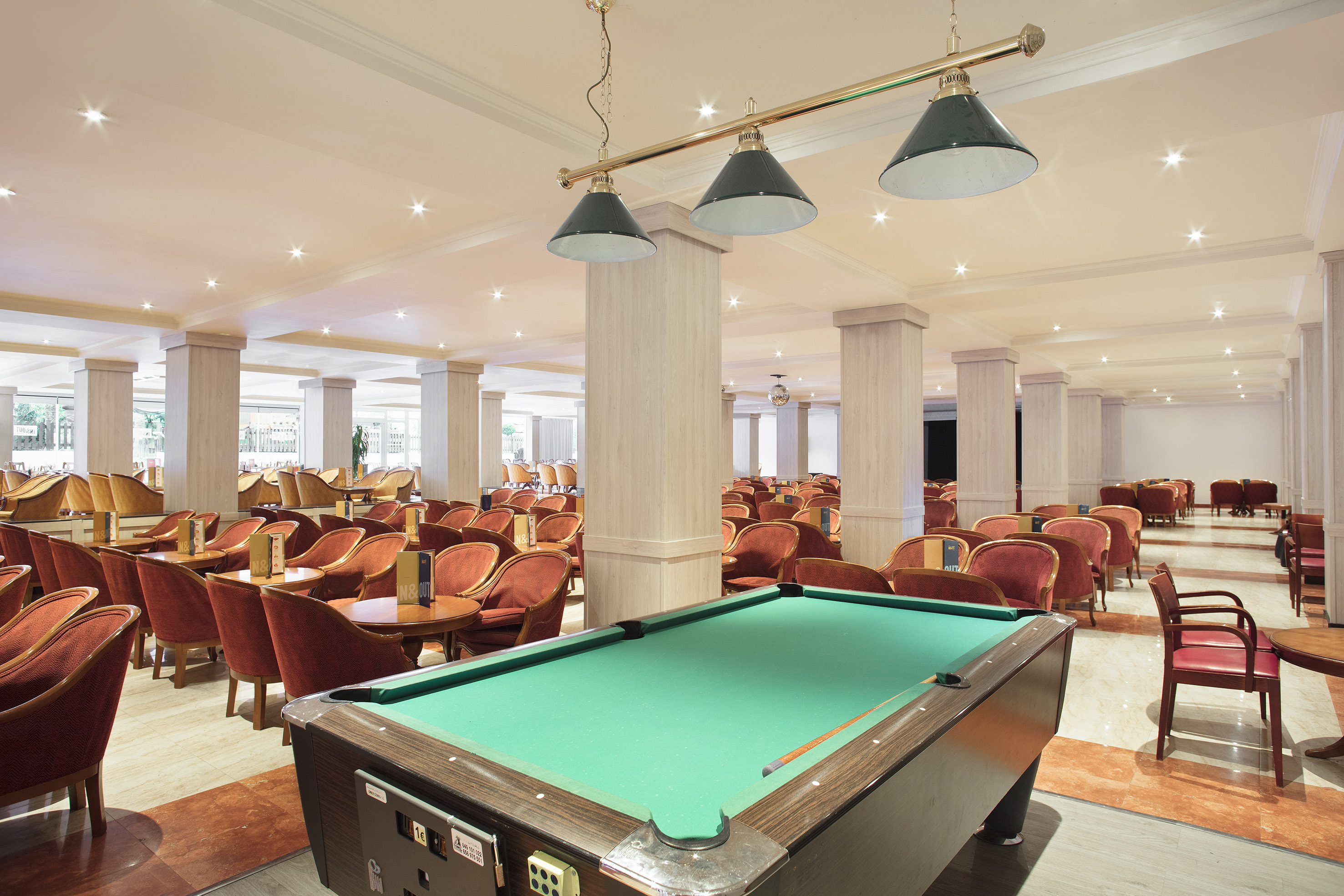 a pool table in a room with chairs and tables