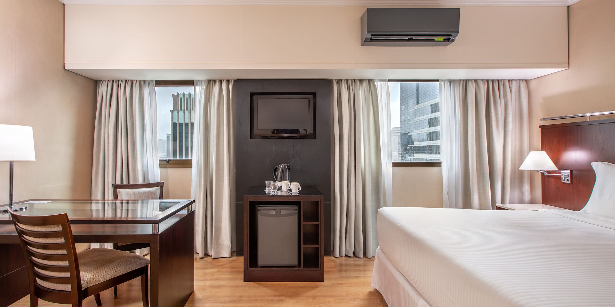 a room with a bed and a table and a television