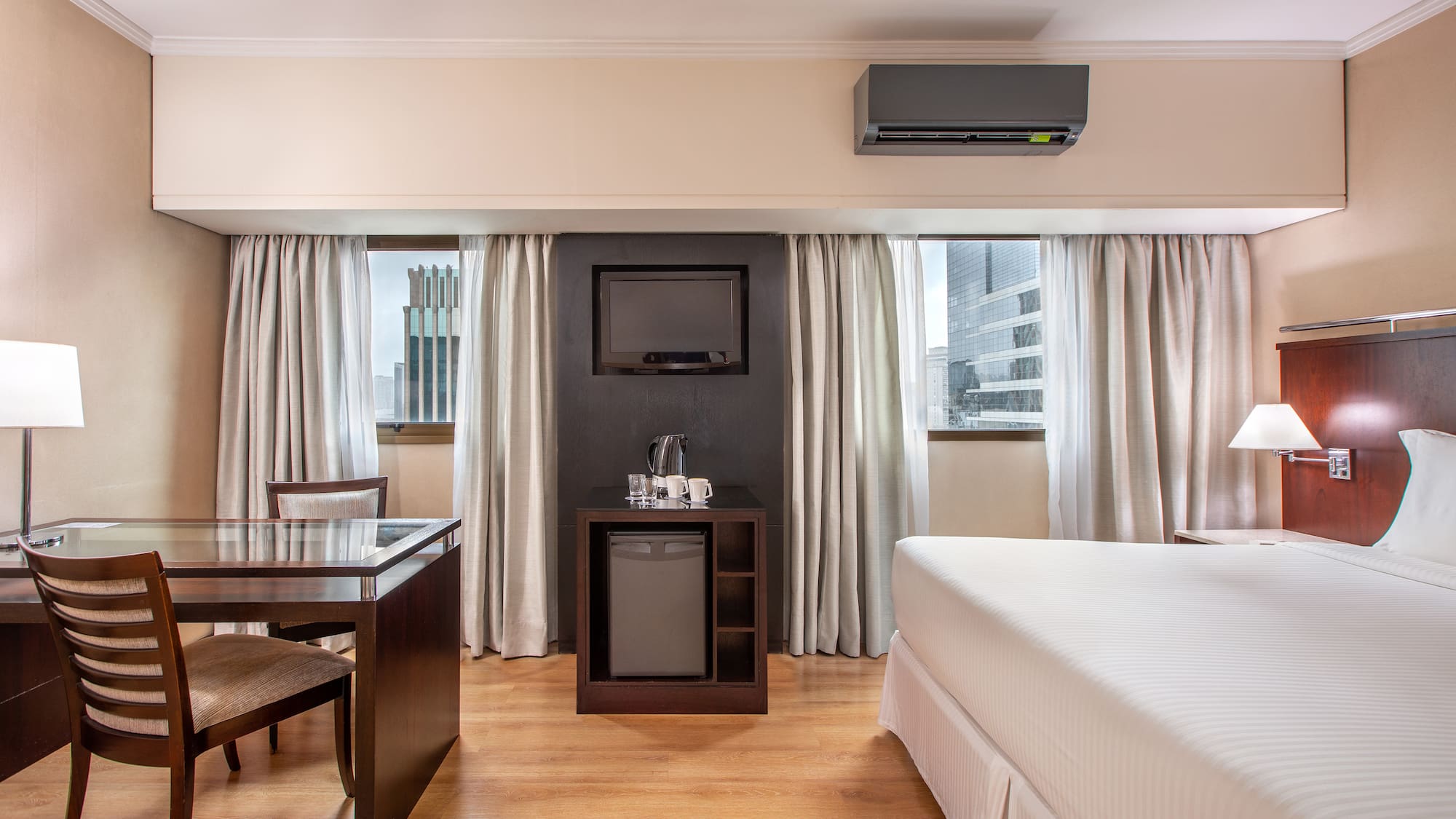 a room with a bed and a table and a television