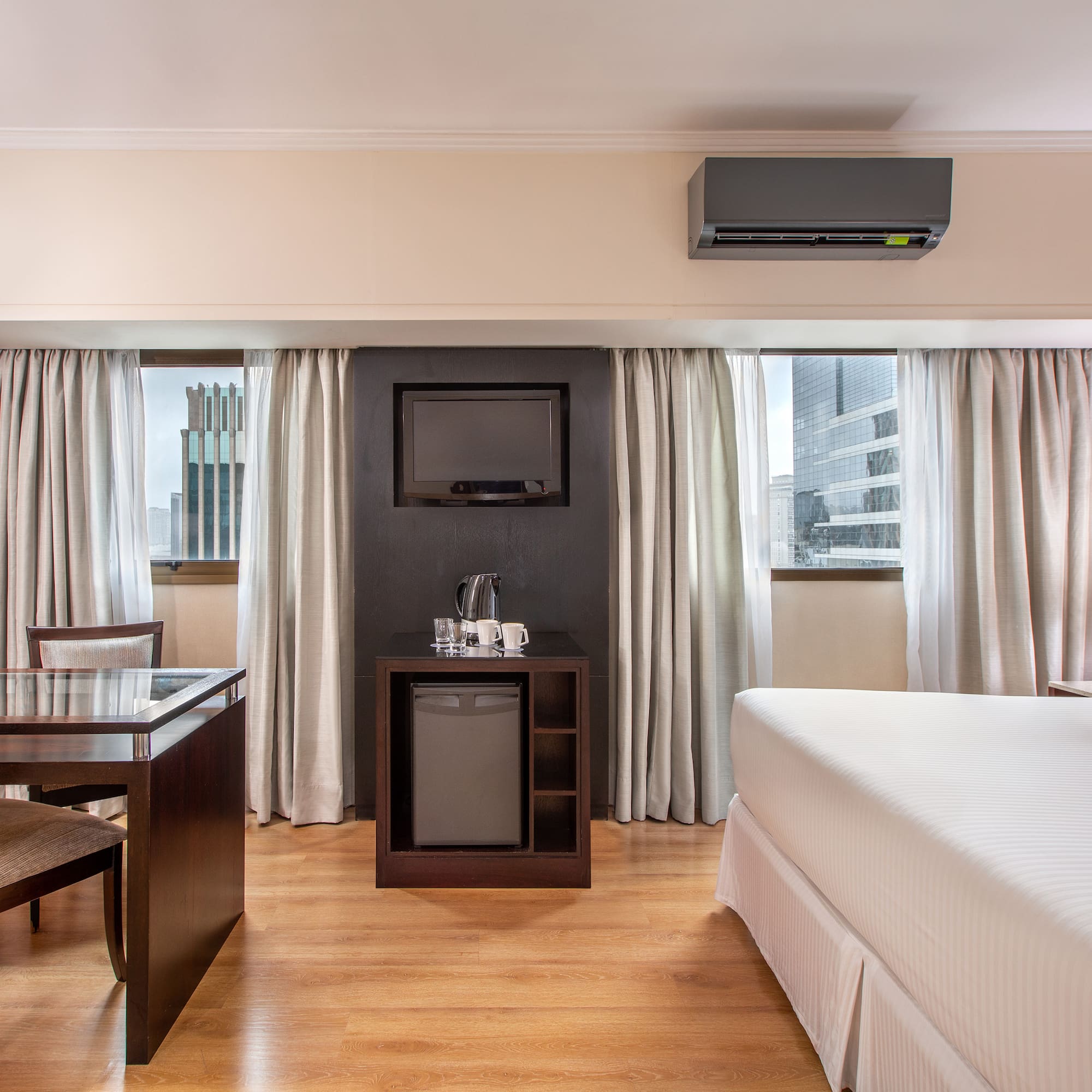 a room with a bed and a table and a television