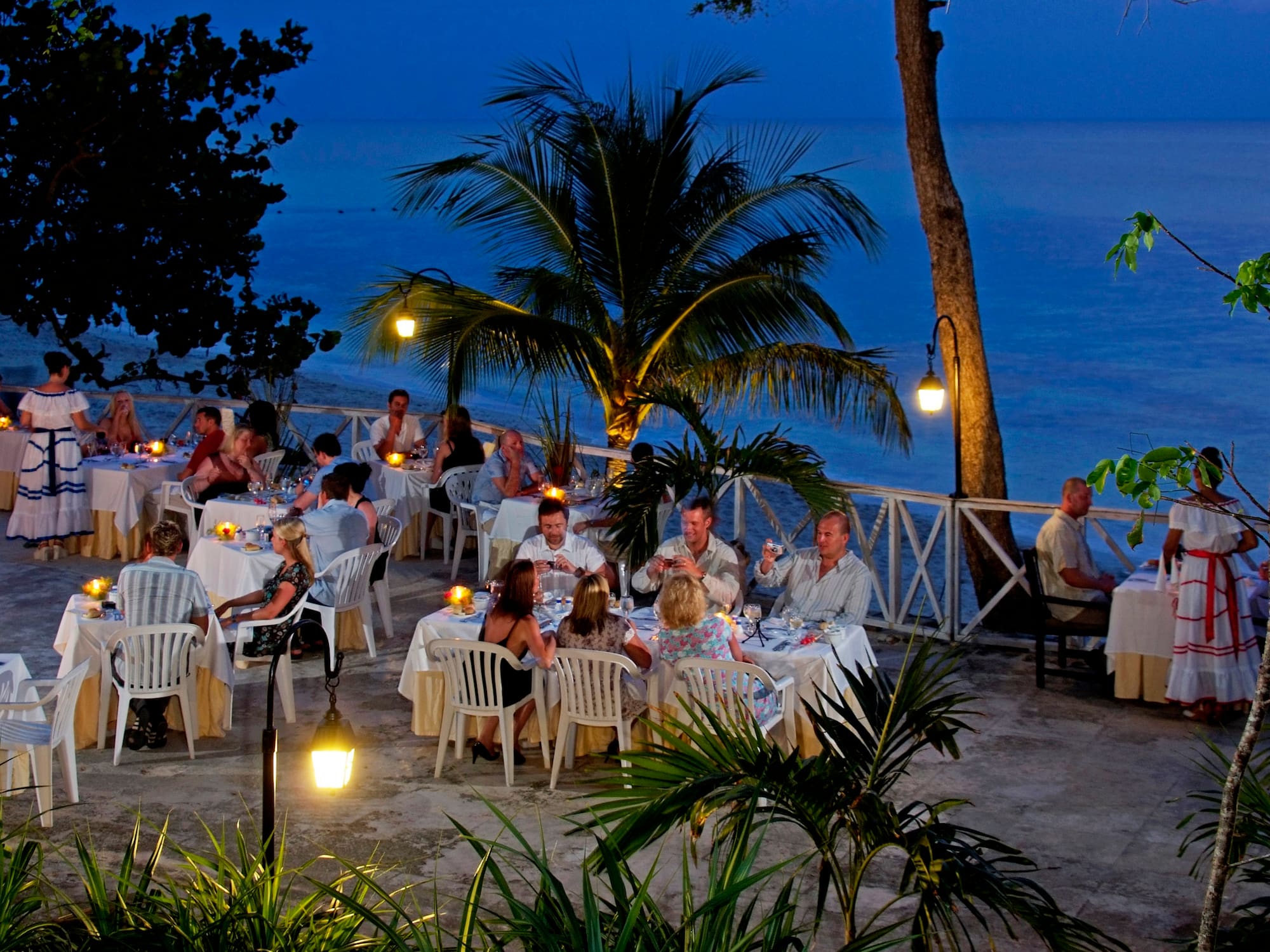 a group of people sitting at tables outside