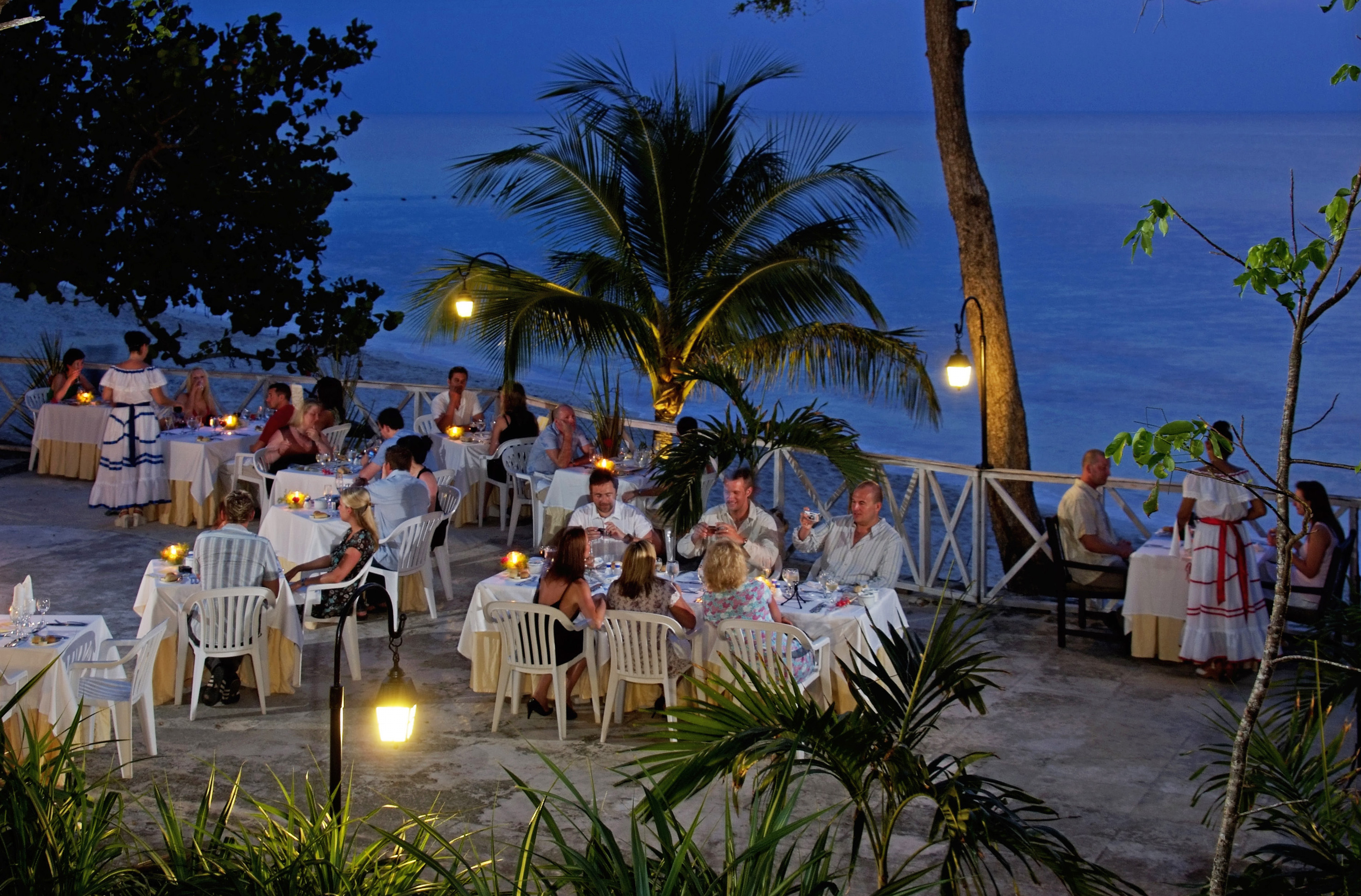 a group of people sitting at tables outside
