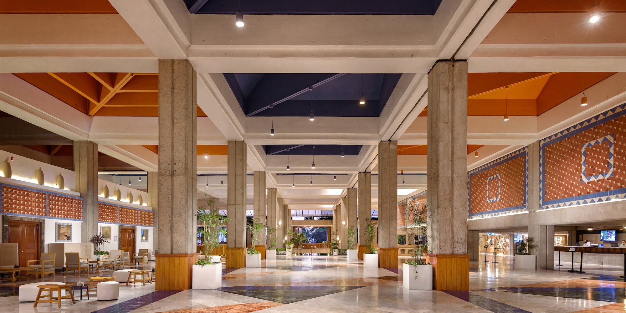 a large hall with columns and plants