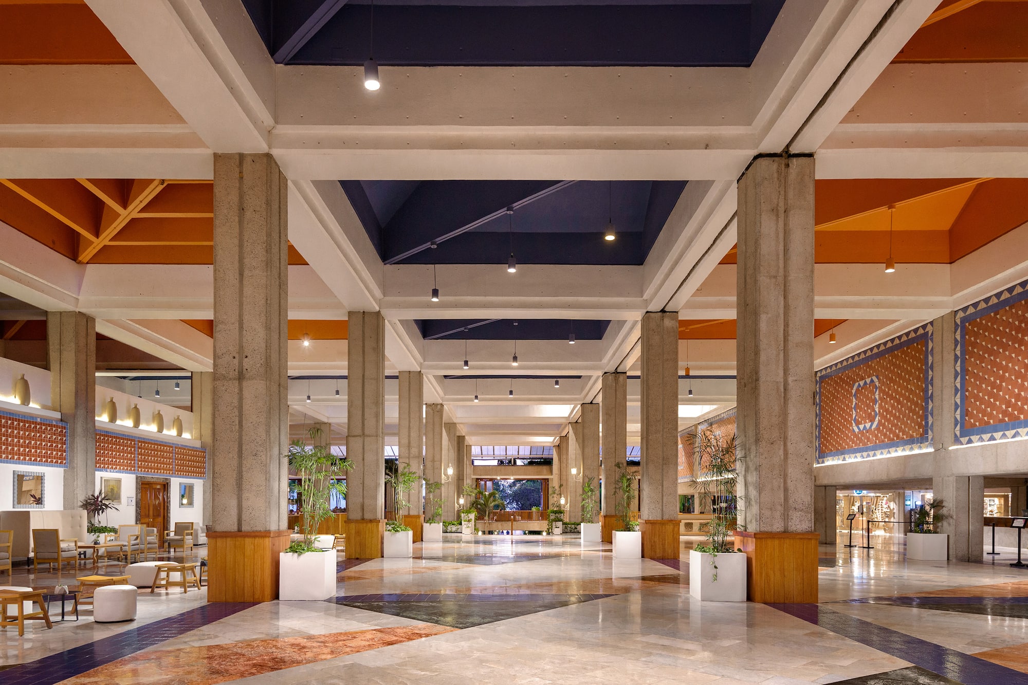 a large hall with columns and plants