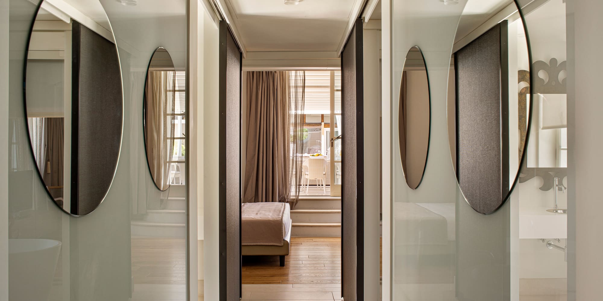 a hallway with mirrors and a bed