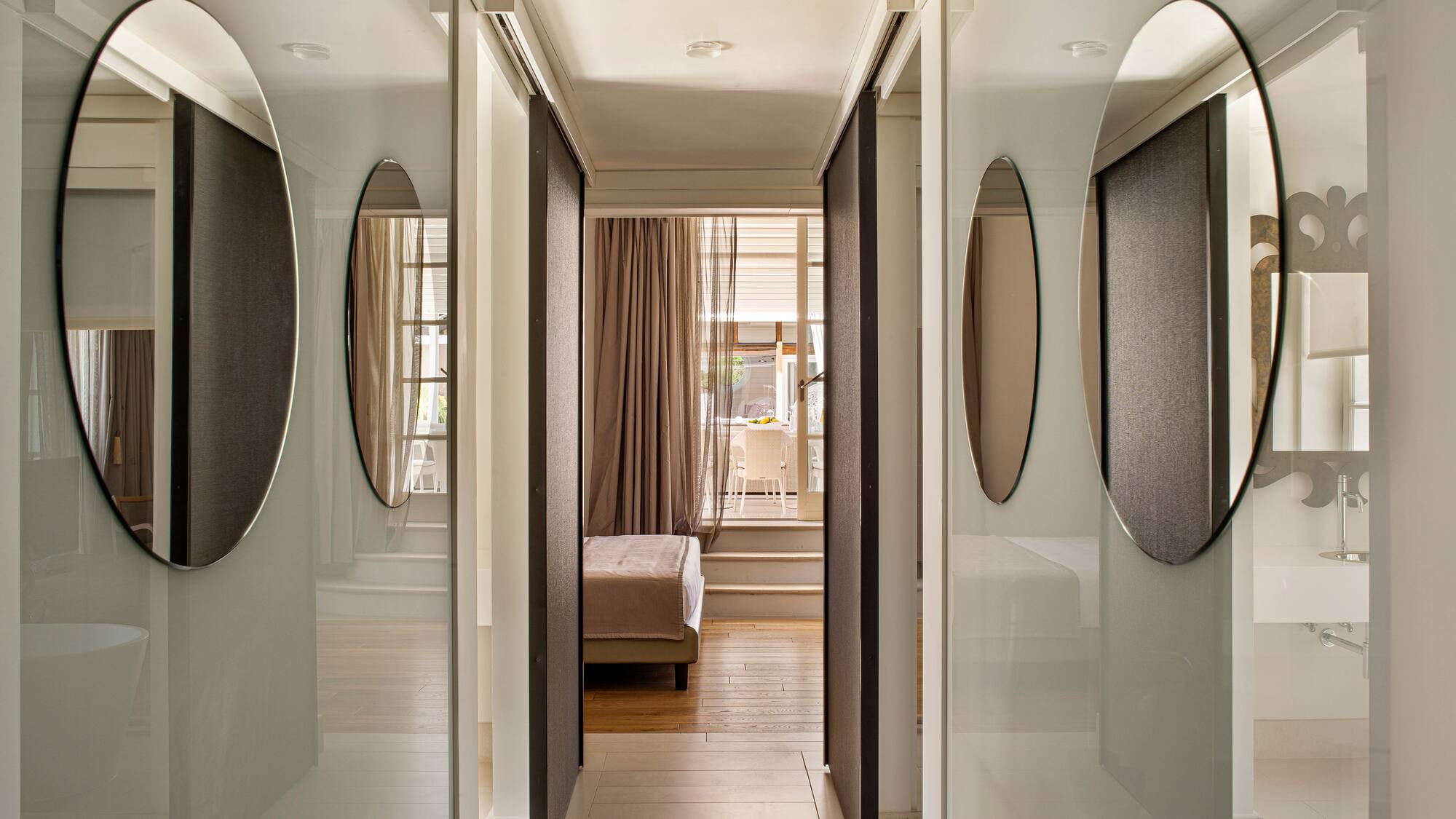 a hallway with mirrors and a bed