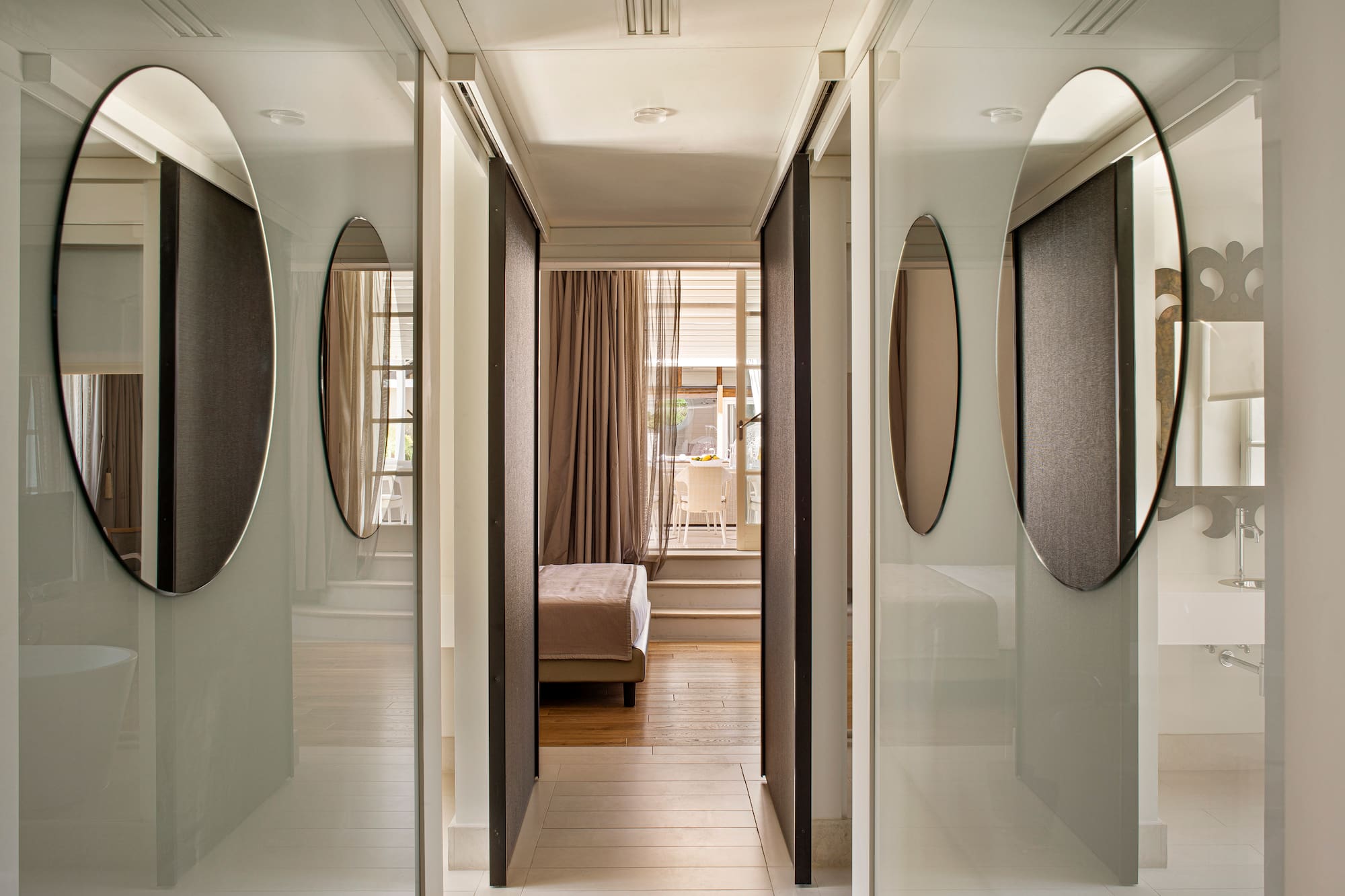 a hallway with mirrors and a bed