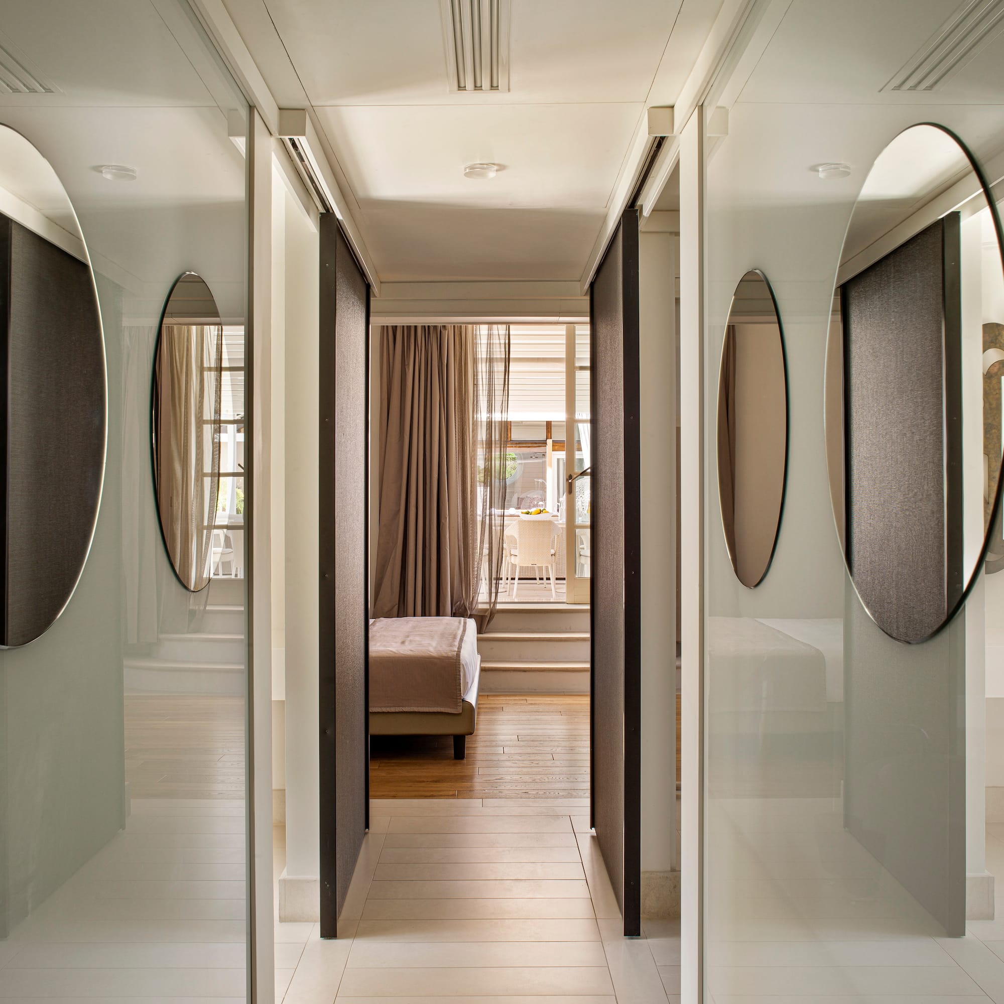 a hallway with mirrors and a bed