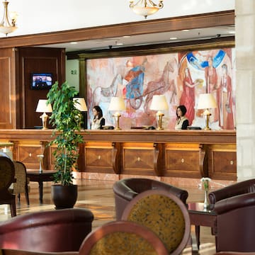 a hotel reception with people behind the counter