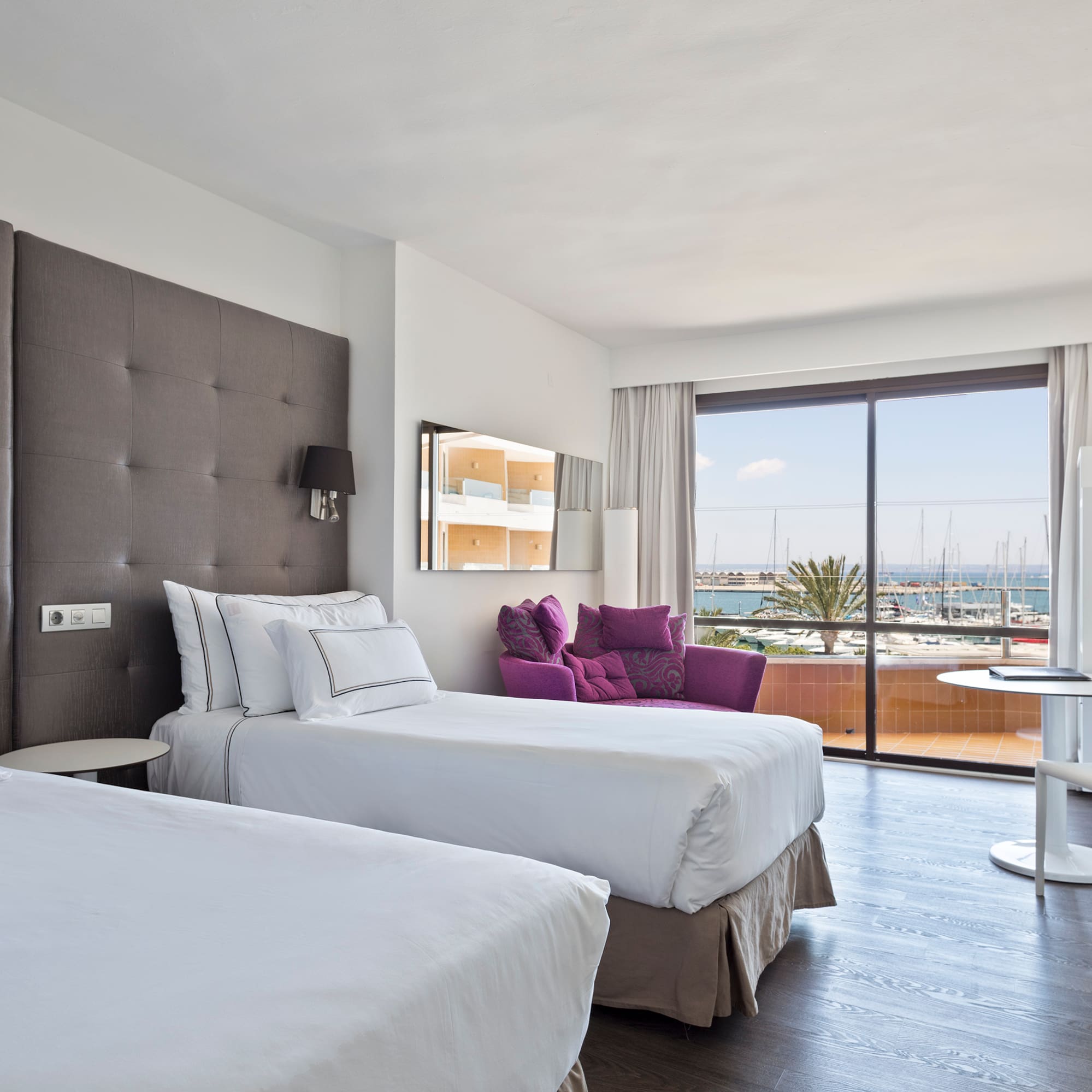 a room with two beds and a table with a glass door