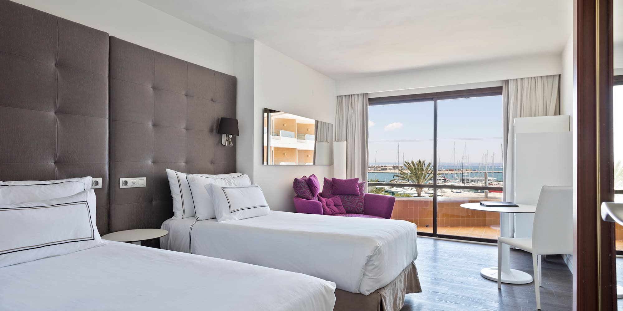 a room with two beds and a table with a glass door