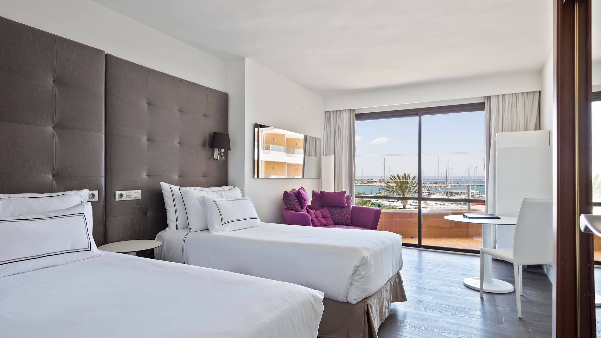 a room with two beds and a table with a glass door