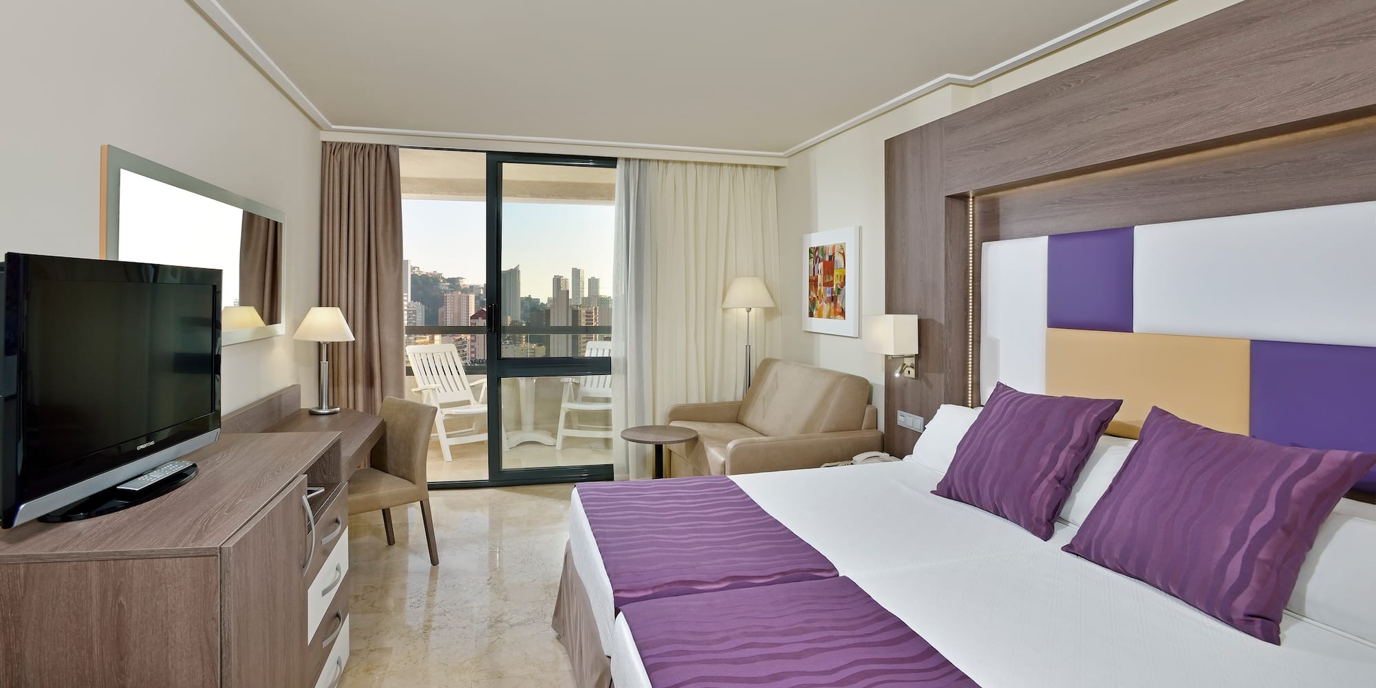 a room with a bed and a chair and a table