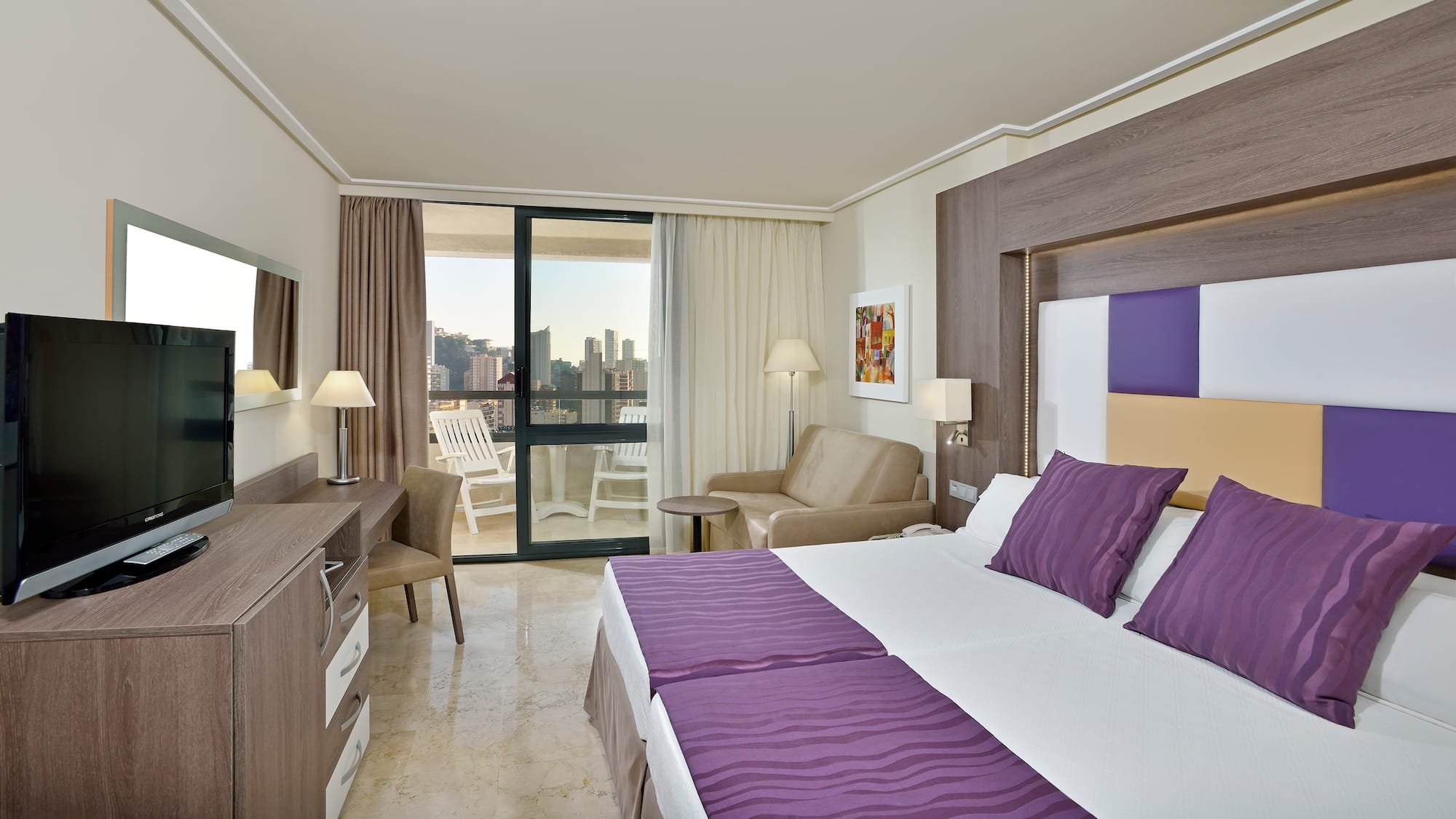 a room with a bed and a chair and a table