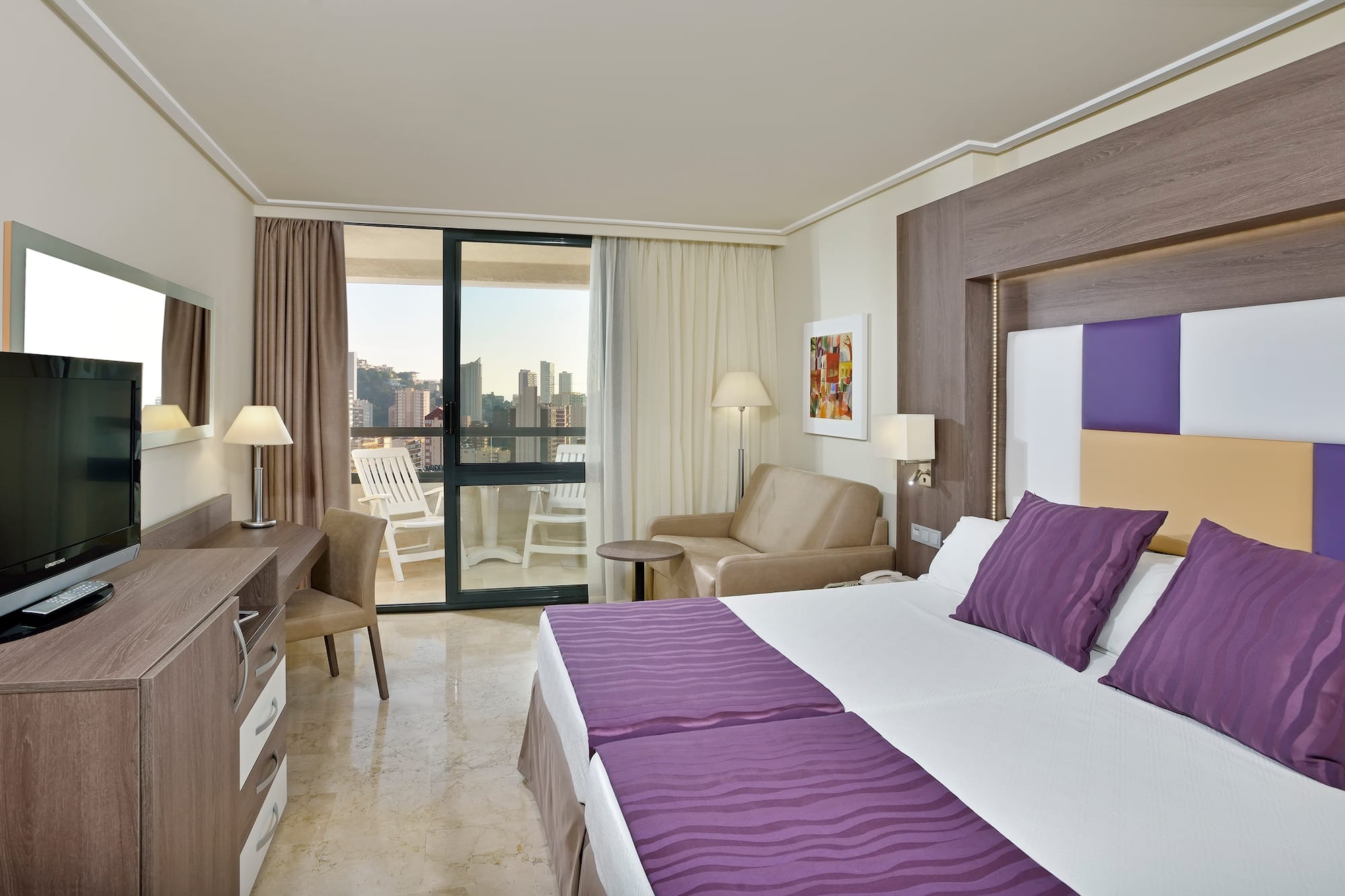 a room with a bed and a chair and a table