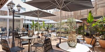 a patio with tables and chairs and umbrellas