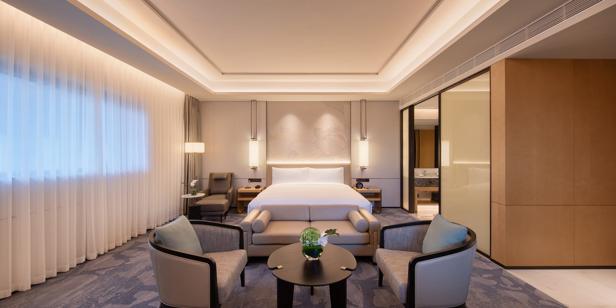 a room with a bed and chairs