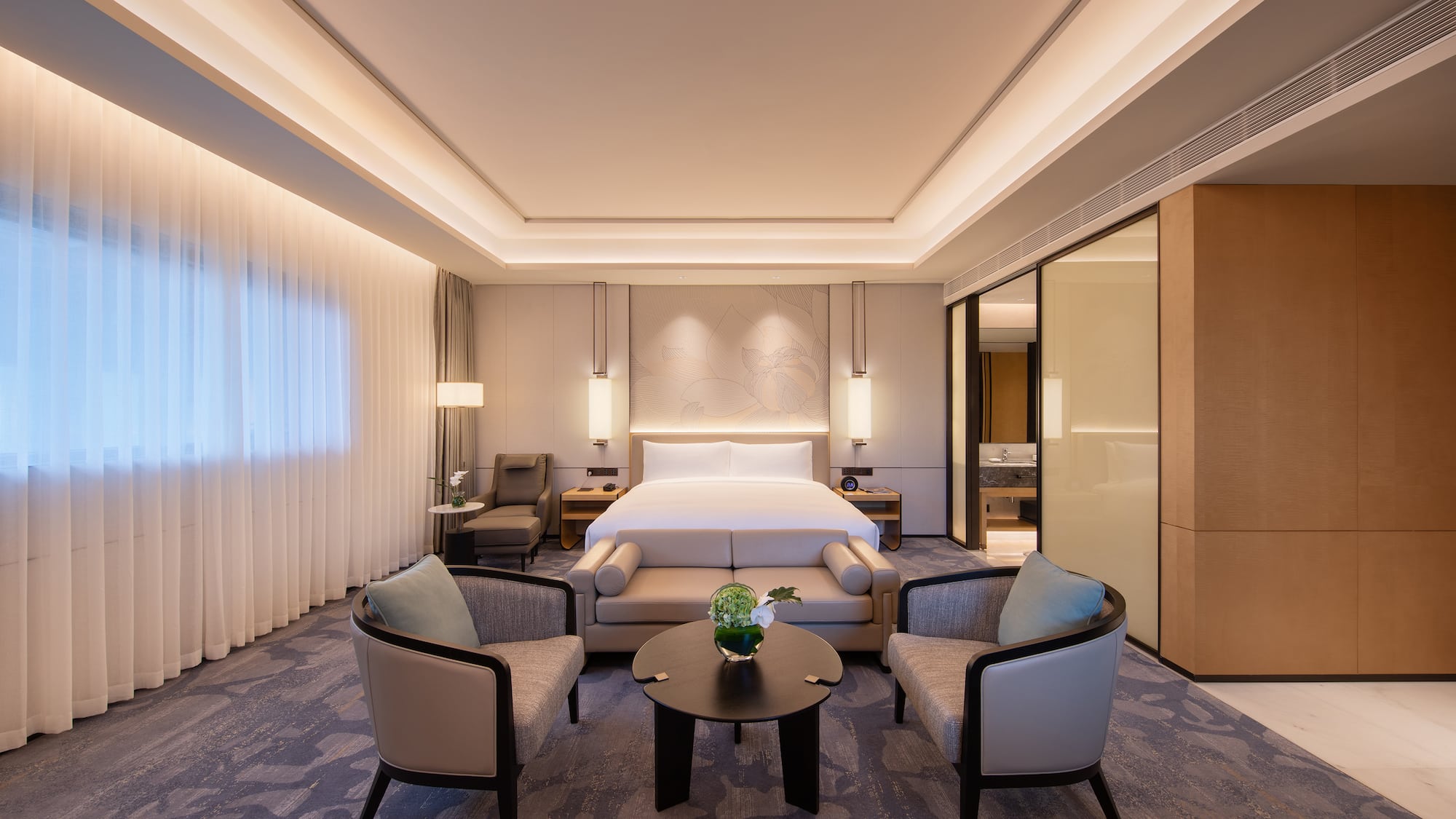 a room with a bed and chairs