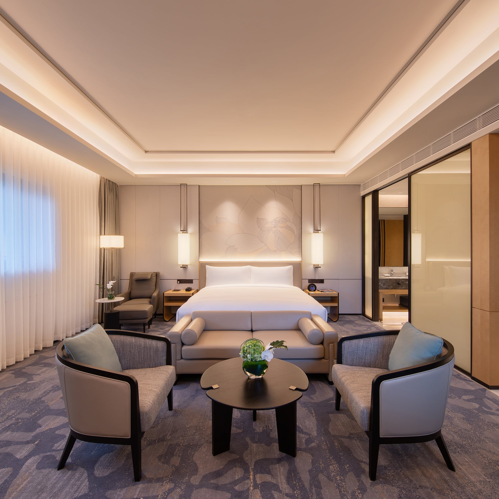 a room with a bed and chairs