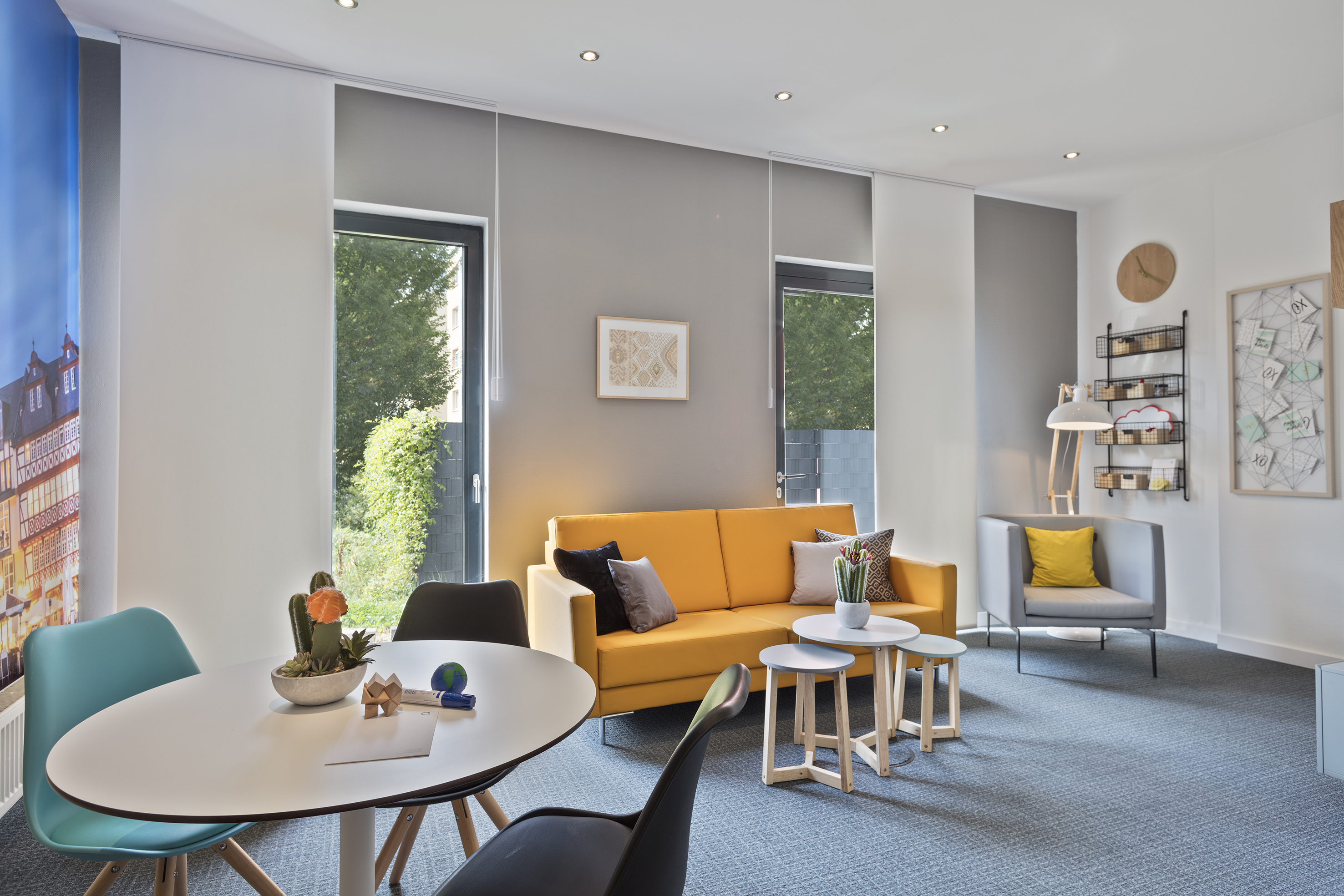 a room with a yellow couch and a white table