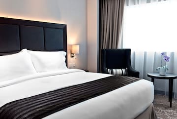 a bed with a black headboard and a chair in a room