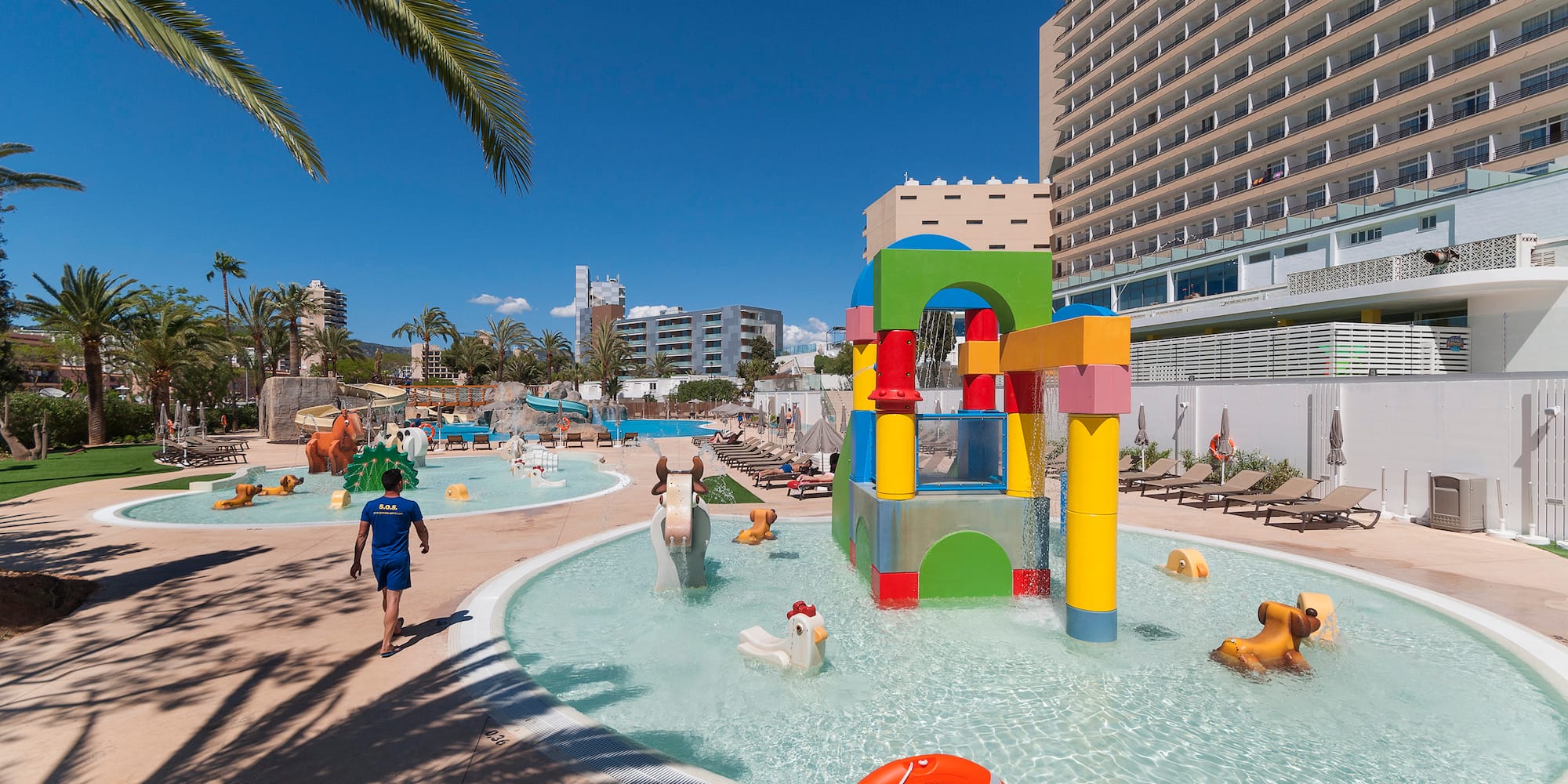 a water park with a large pool and people walking around