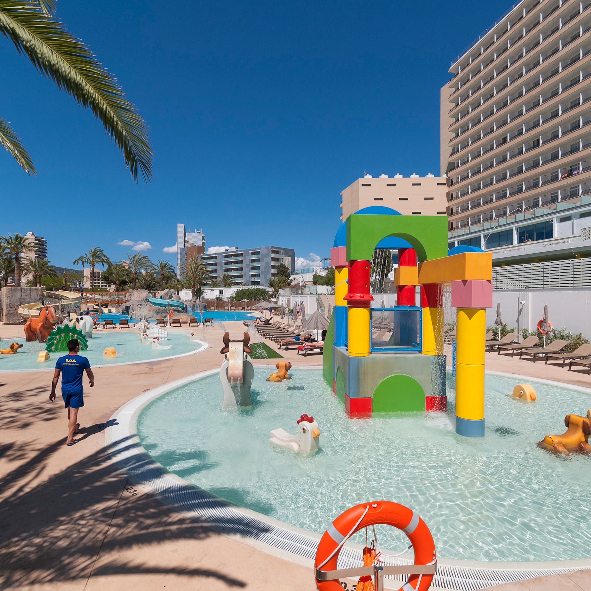 a water park with a large pool and people walking around