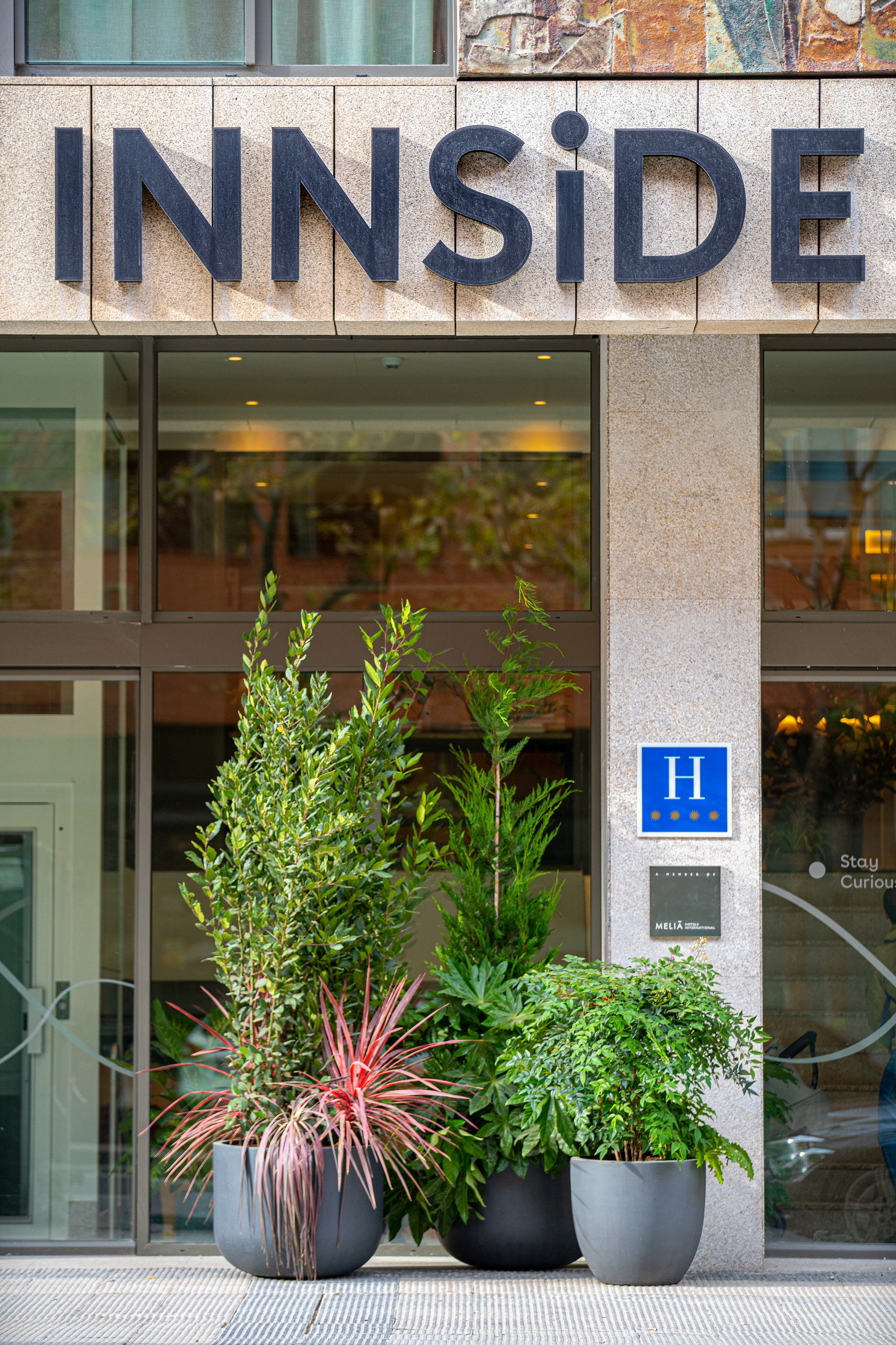 a building with a sign and plants