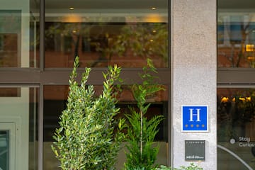 a building with a sign and plants
