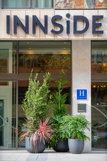 a building with a sign and plants