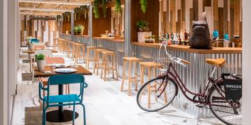 a room with tables and chairs and a bicycle