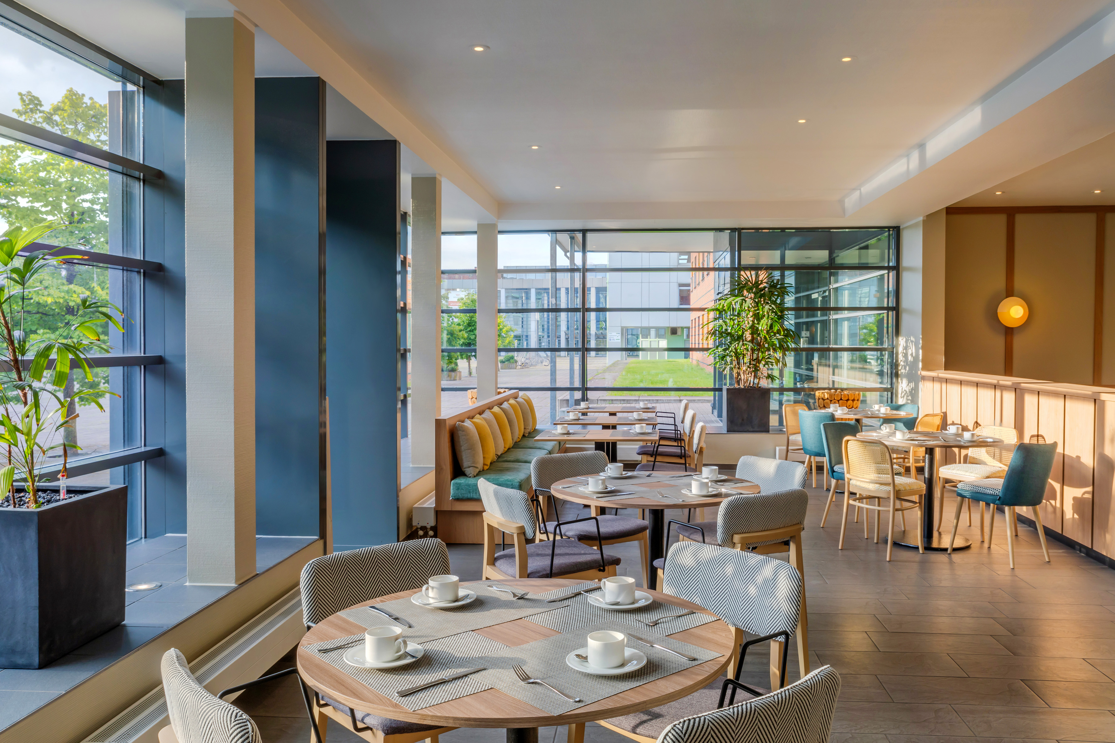 Bright modern restaurant with set tables, stylish seating, large windows. - Hotel Münster Kongresscenter Affiliated by Meliá, ミュンスター