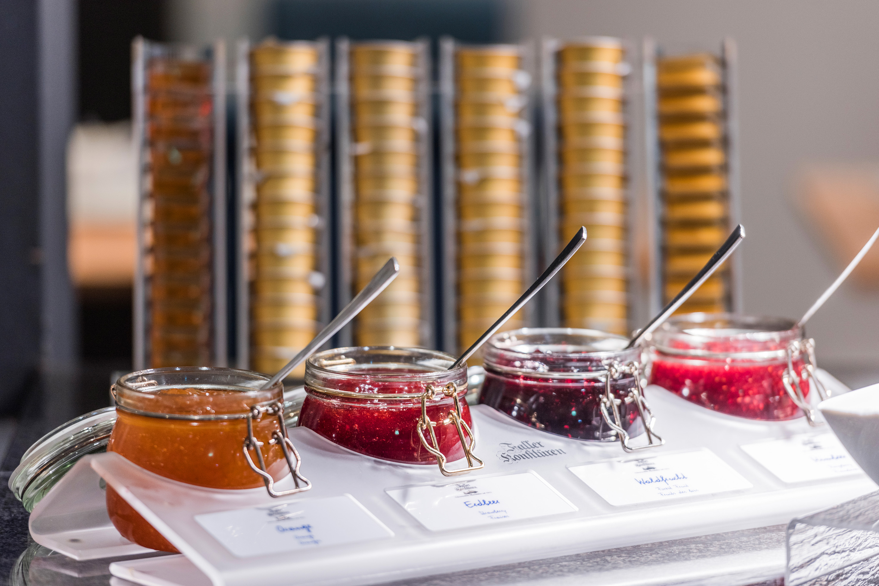 Display of assorted fruit jams: orange, strawberry, and mixed berry preserves.