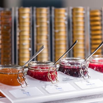 jars of jam in a container with spoons