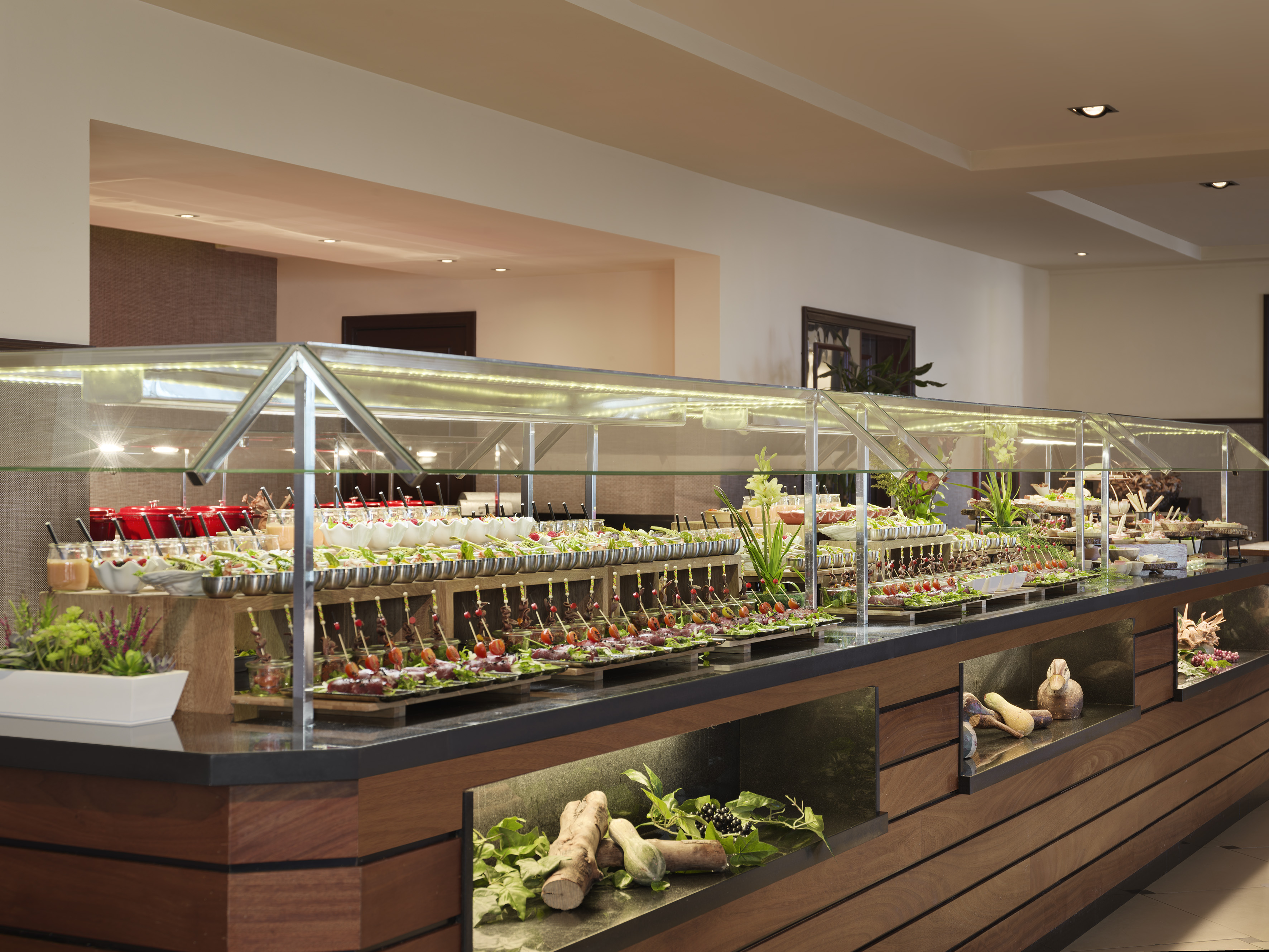 Elegant buffet with fresh appetizers, small dishes, and salads under glass covers.