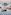 Boats anchored in a calm bay with a rustic wooden stilt shack.