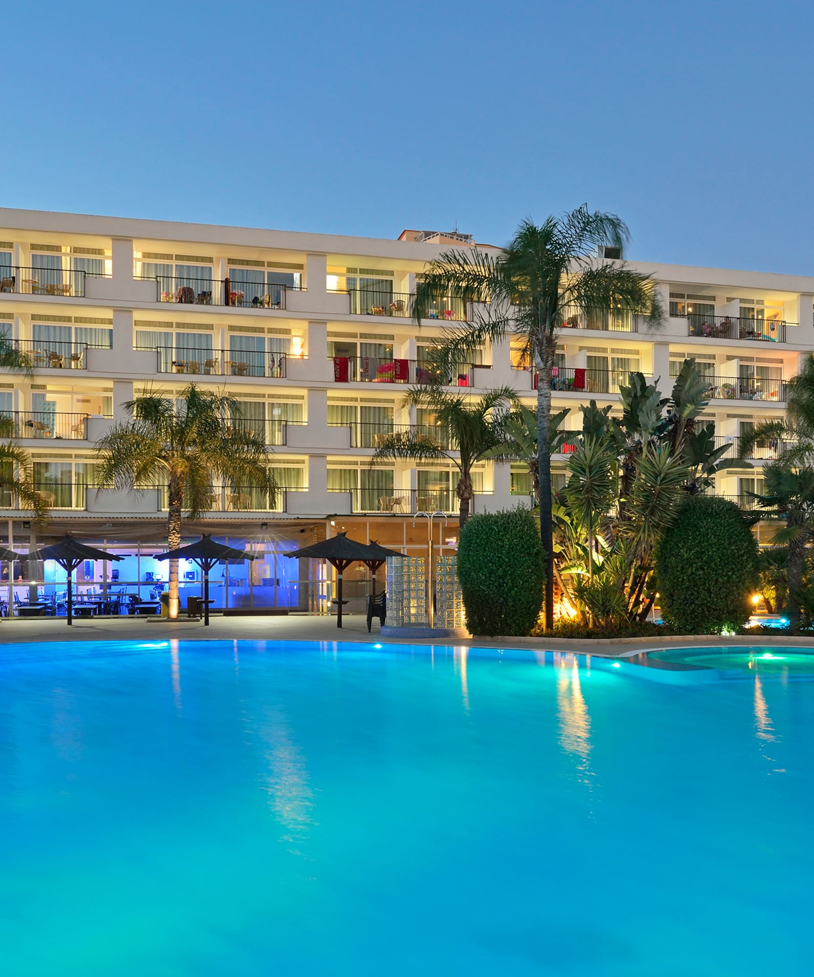 a pool with a building and palm trees