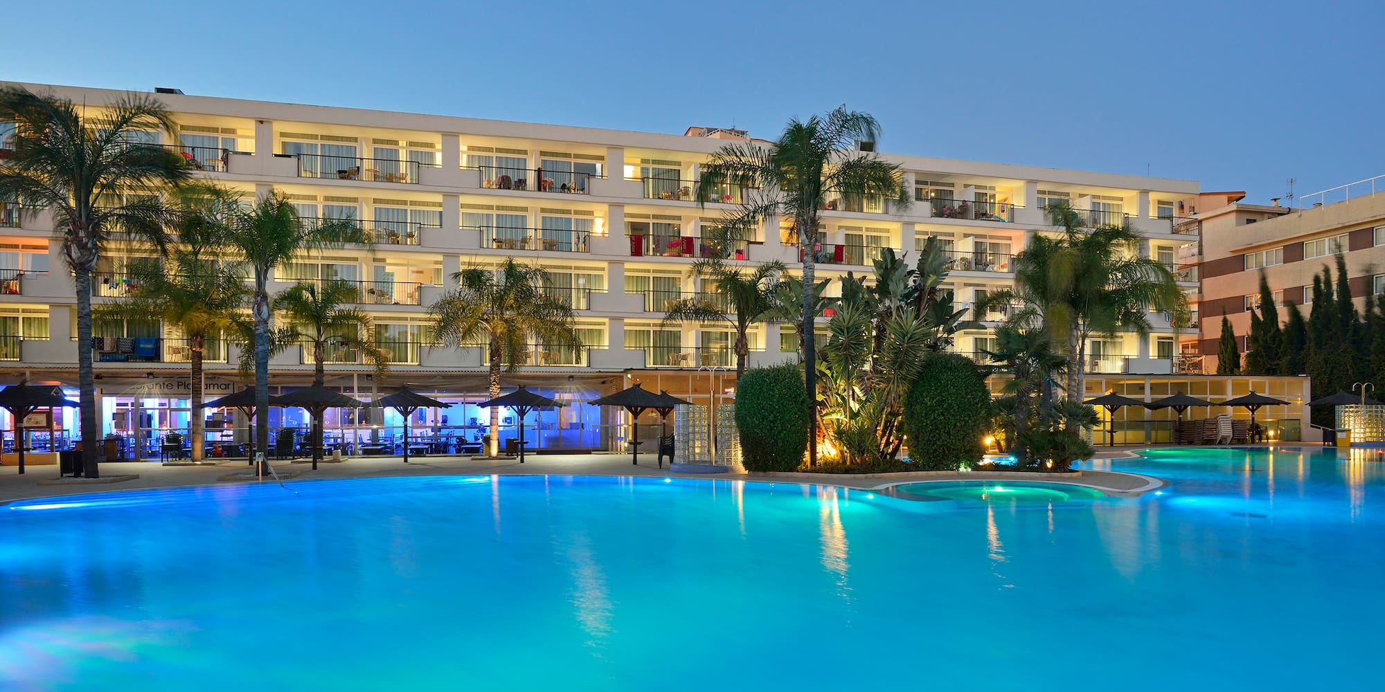 a pool with a building and palm trees