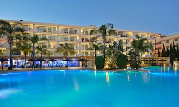a pool with a building and palm trees