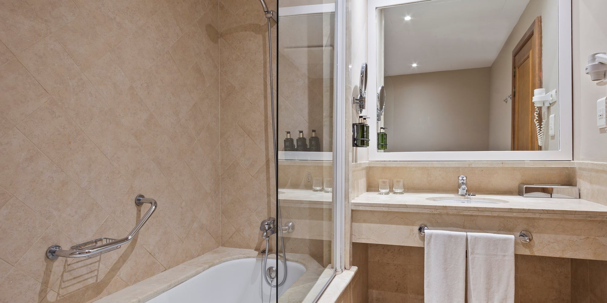 a bathroom with a glass shower door and a bathtub