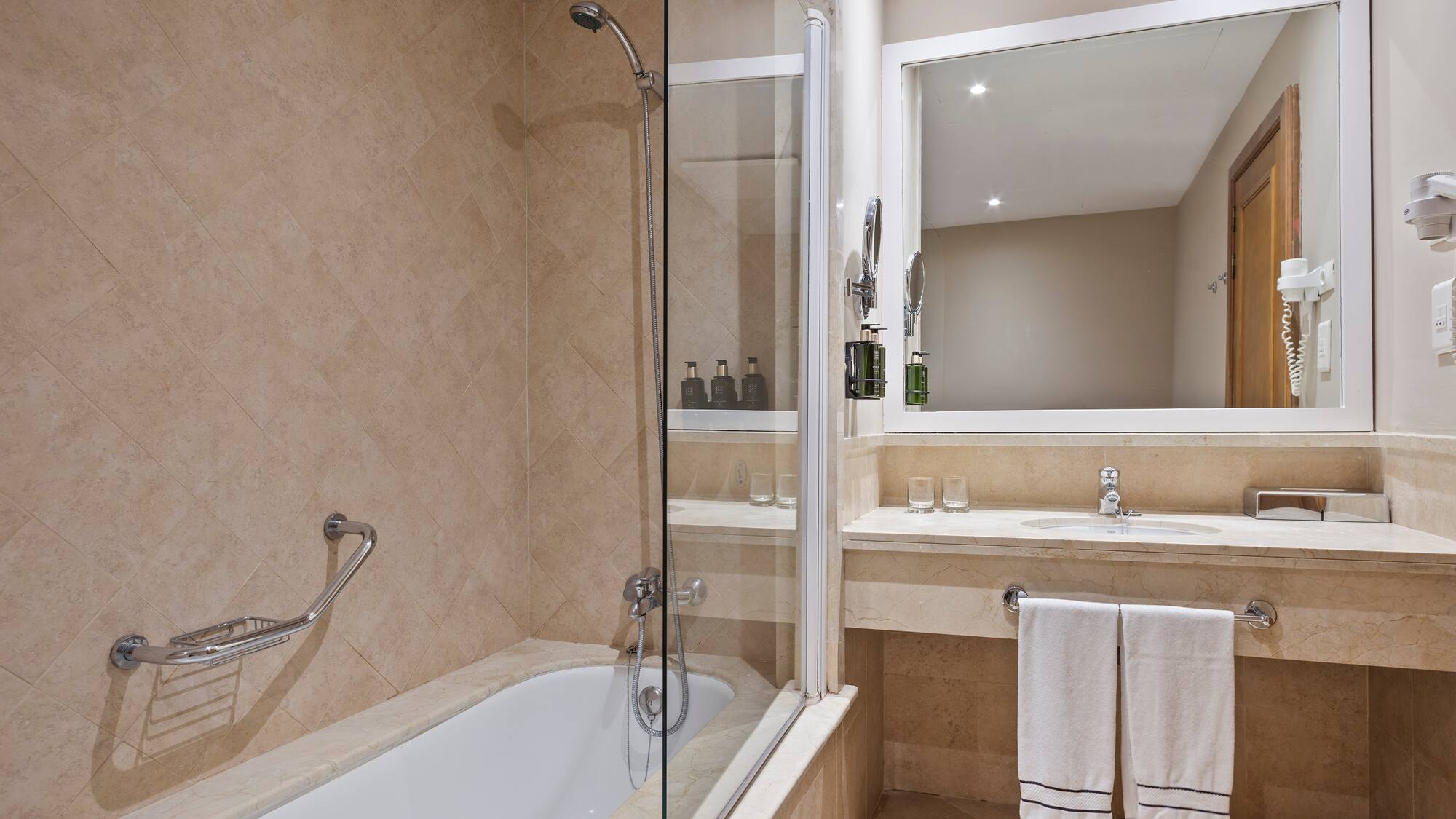 a bathroom with a glass shower door and a bathtub